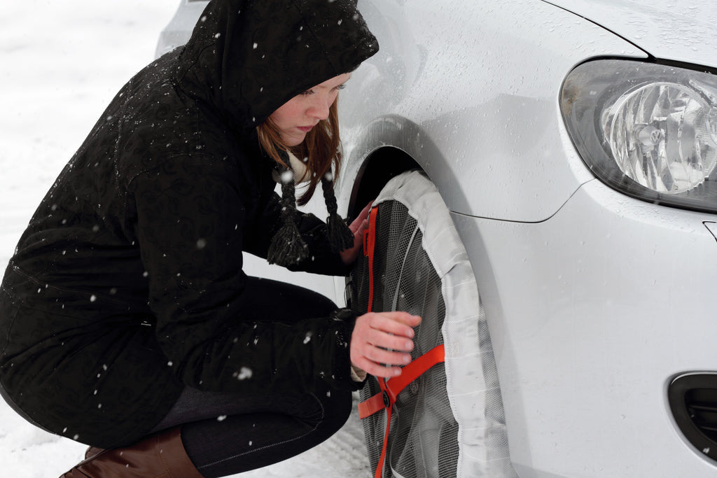 Woman installs AutoSock for cars on the front wheels