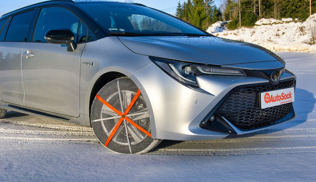 Snow Socks mounted on front wheels of a Toyota estate car