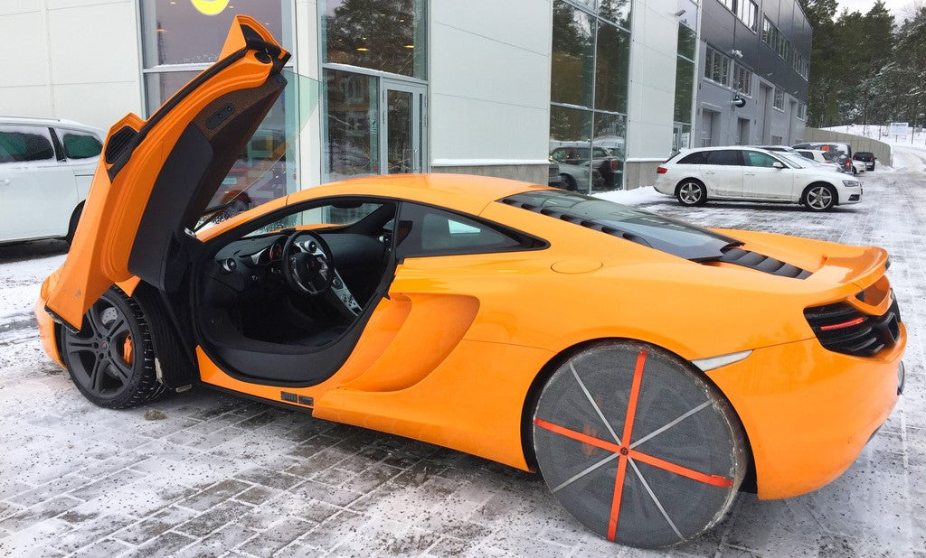 AutoSock mounted on rear wheels of a sports car standing on snow and ice