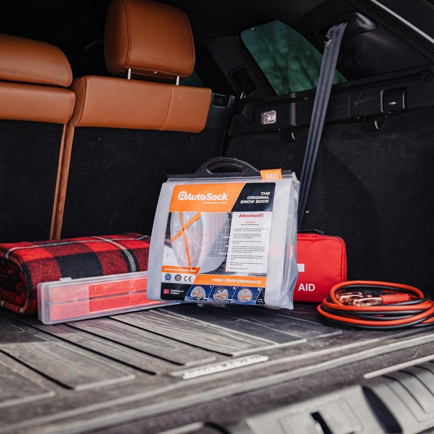 Snow socks product packaging in trunk of a SUV with other car accessory