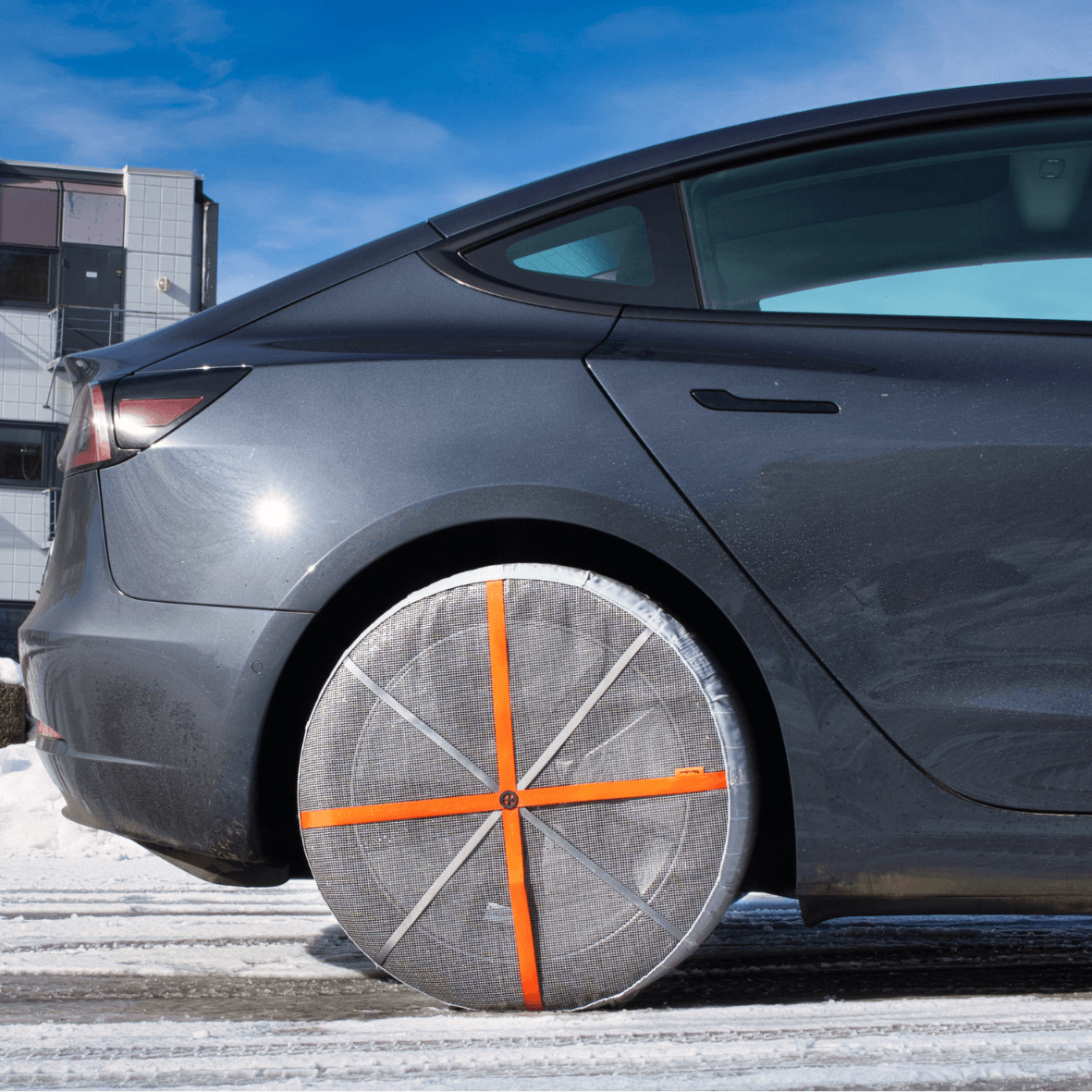 AutoSock textile tire chains installed on rear wheels of a Tesla electrical car